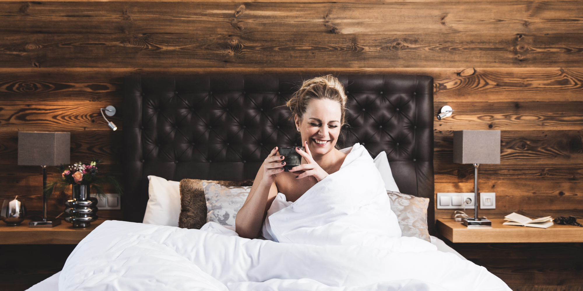 Frau trinkt Ihren Kaffee im gemütlichen Bett im 4* Sterne Hotel Montanara