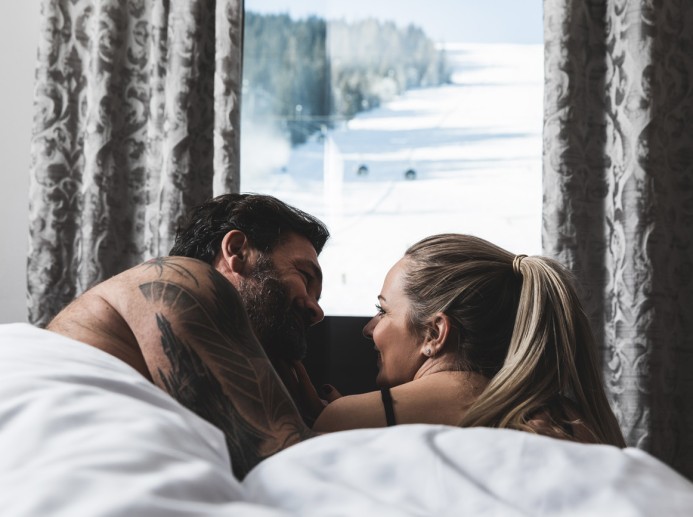 Paar blickt vom Zimmer aus auf die Skipiste in Flachau